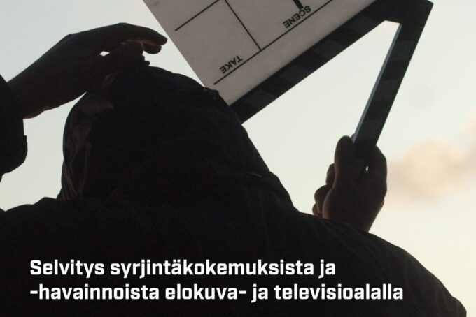 Elokuva- ja tv-työntekijän silhuetti pitää klaffia ylhäällä.